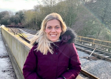 Miriam Cates MP in front of rail lines talking about UK steel