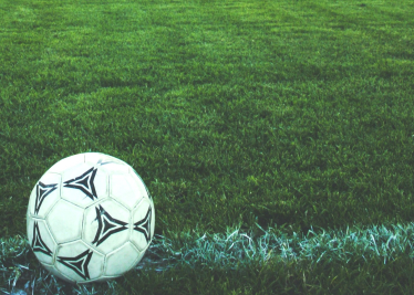 A football in a field depicting childhood lost to smartphones