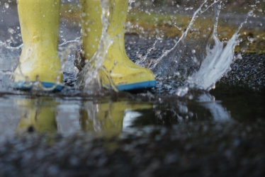 Childhood innocence splashing in boots