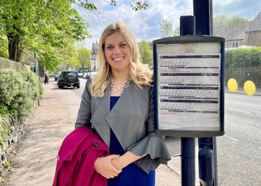 Miriam waiting at a bus stop - announcing £130 million in funding